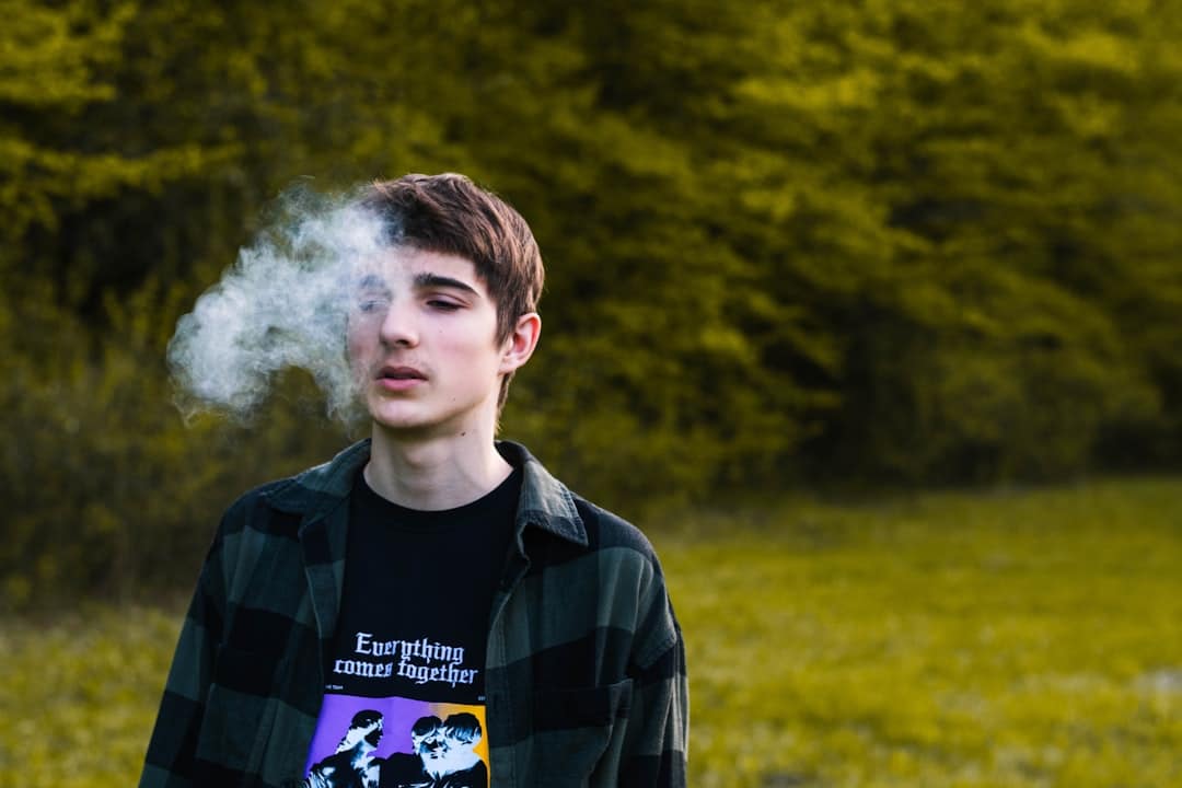Photo by Sebastian Radu a man with a white cloud of smoke behind him